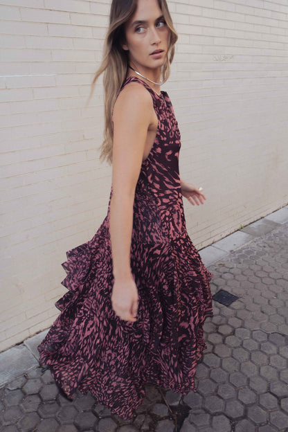 Mujer posando con Vestido Sunset de HiCute, vestido largo fluido color granate y rosa con estampado animal y volantes.